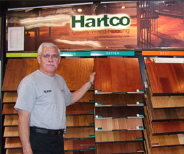 Image of Sam Riddle with hardwood floor samples. 